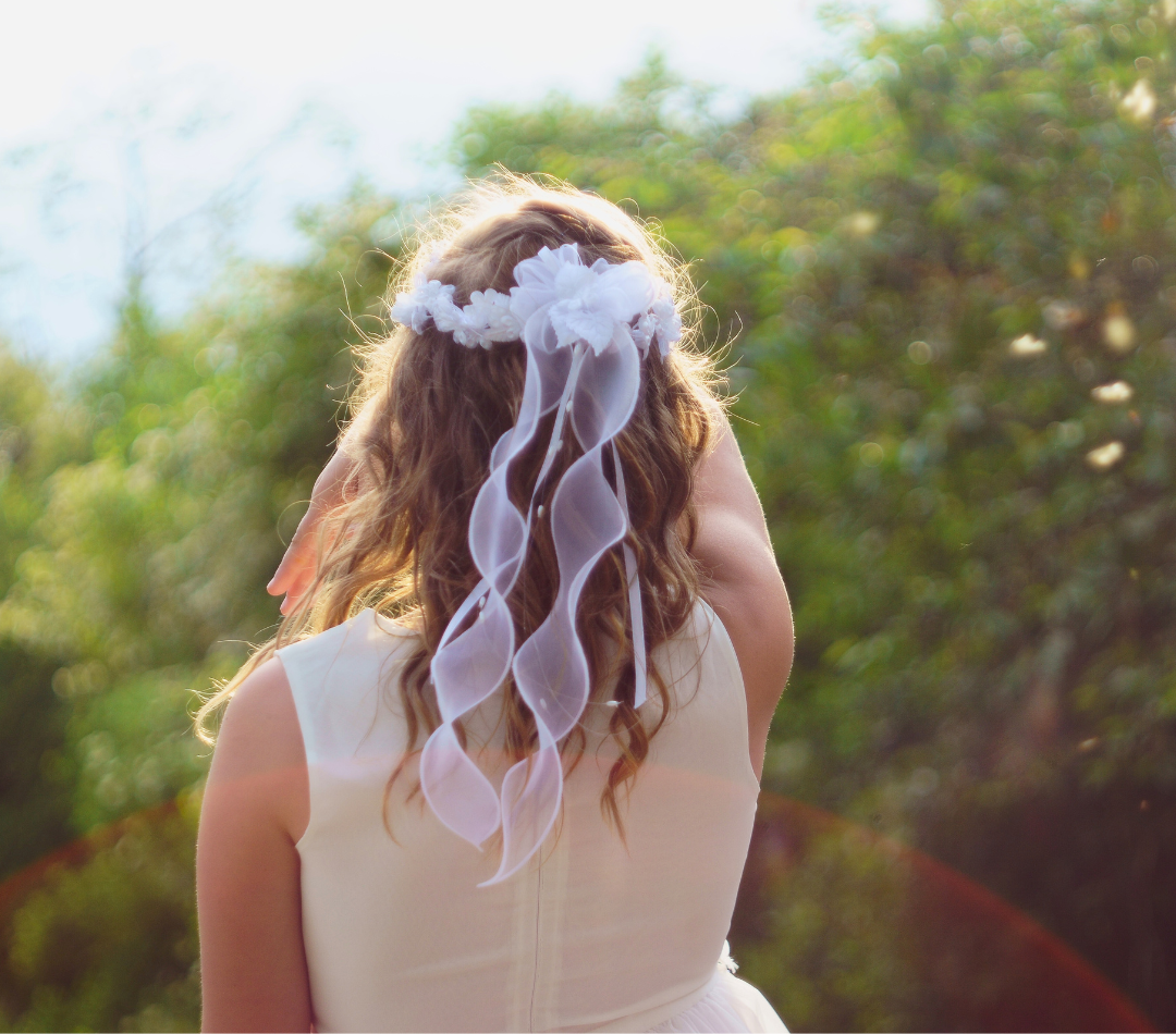 Niña vestida con traje de comunión de espaldas